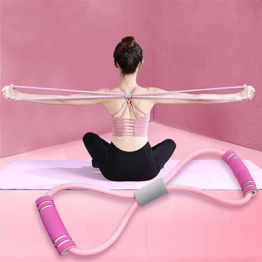 Woman using pink resistance band for home workout, seated on yoga mat in pink room