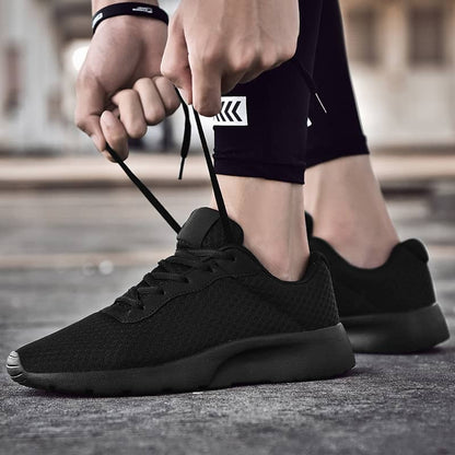 Person tying black athletic shoes on a blurred background
