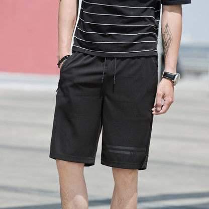 Person wearing black shorts and a striped shirt with a blurred background