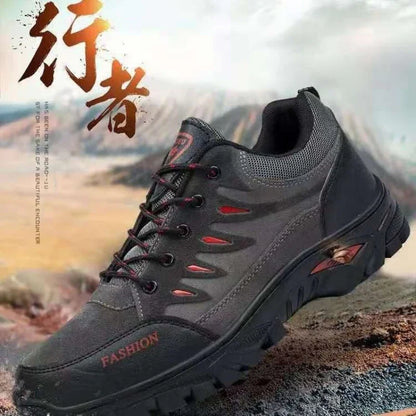 Black and red outdoor trail running sneaker on rugged terrain with mountain background