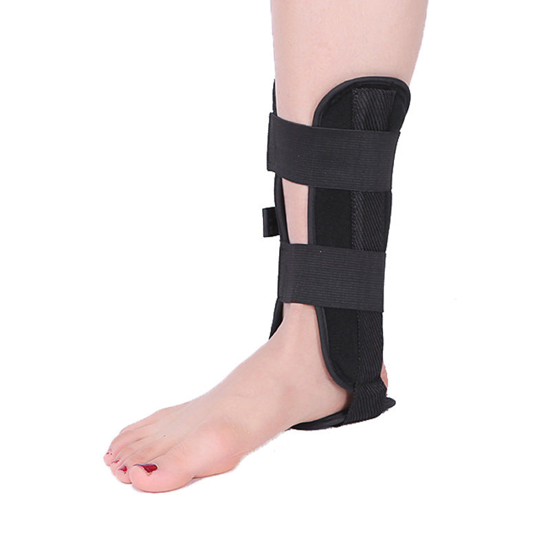 Black ankle support brace on a person's foot against a white background