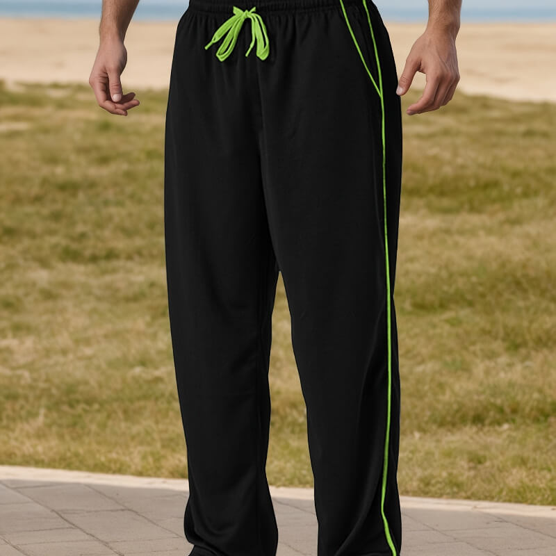 Black pants with green drawstring and side stripe on a grassy background