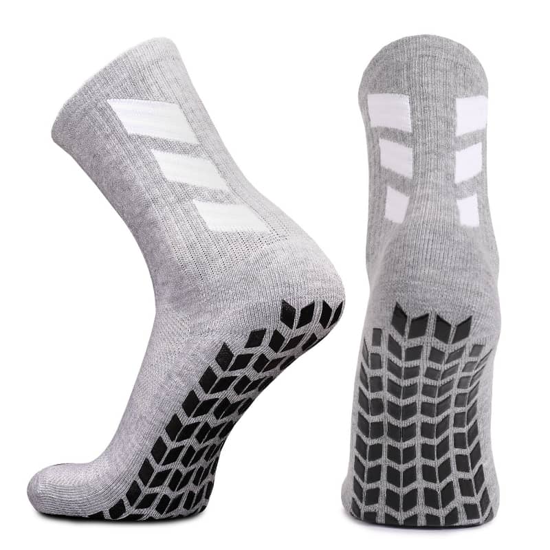 Gray socks with white logo and black pattern on sole against a white background