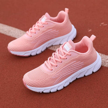 Pair of pink running shoes on a brown surface
