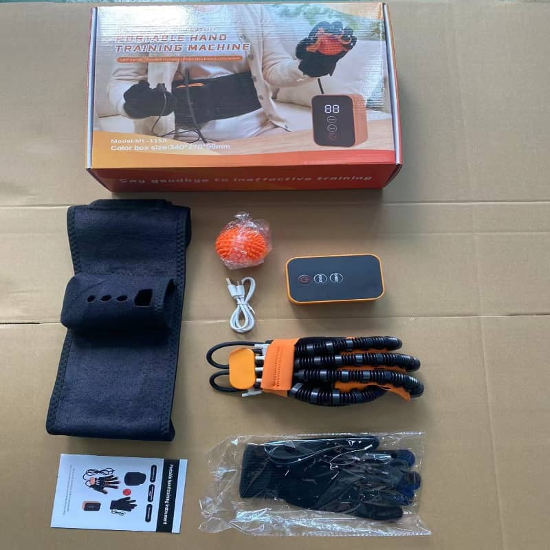 Hand training machine components on a cardboard surface with packaging in the background.