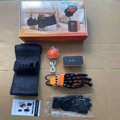 Hand training machine components on a cardboard surface with packaging in the background.