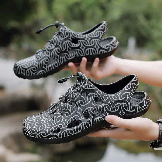 Black and white patterned shoes held by a person with a natural background