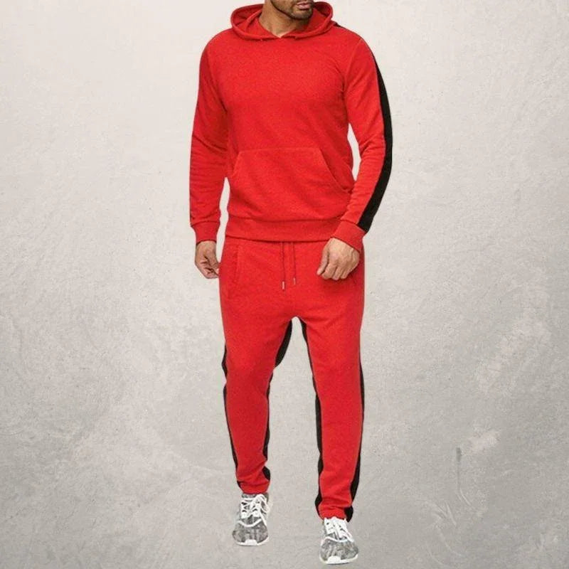 Man wearing red hoodie and matching joggers with black side stripes, styled for fitness and casual wear