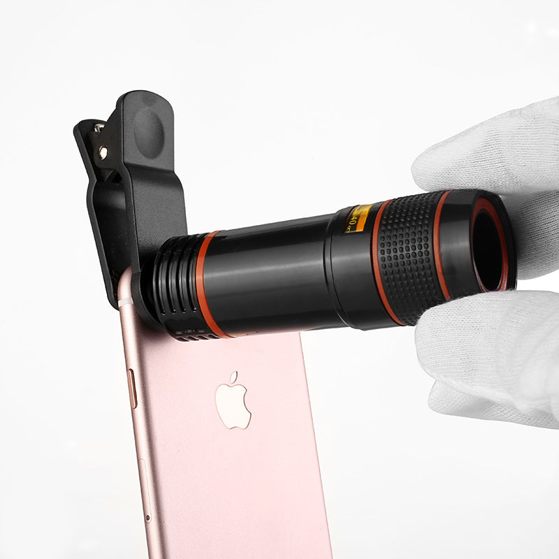 Phone with a telescope attachment held by a gloved hand on a white background