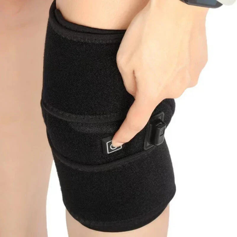 Adjustable black thigh compression wrap with a control button, worn on a person's leg