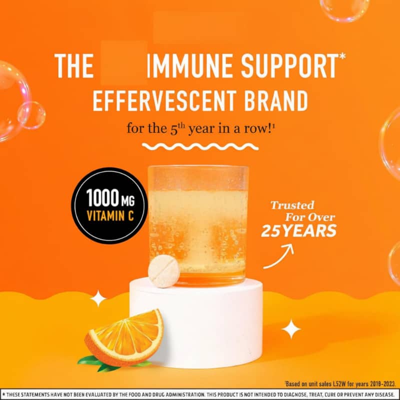 Effervescent vitamin C immune support supplement with orange, tablet and drink on orange background