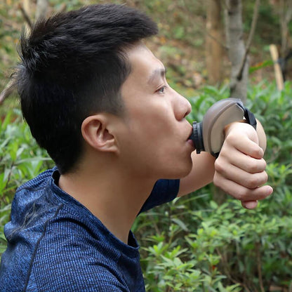 Man outdoors drinking from wearable water bottle for fitness and hiking