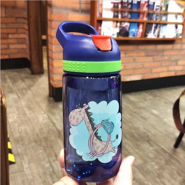 Blue fitness water bottle with green band and giraffe cartoon design, held in hand indoors