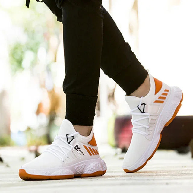 White and orange sports sneakers worn with black pants, outdoor fitness footwear by Hi Fitness