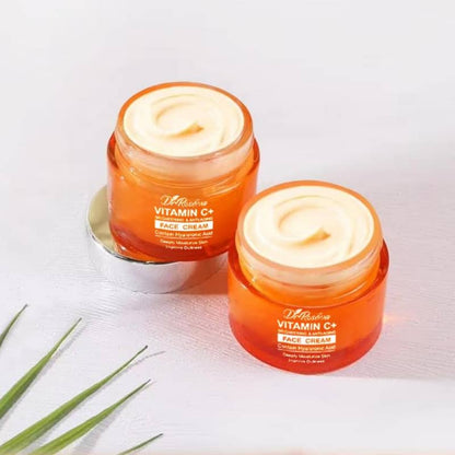 Two jars of Vitamin C face cream on a light background with green leaves.