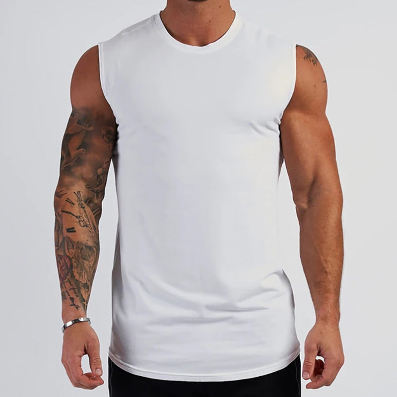Person wearing a white sleeveless shirt with tattoos on arms against a plain background