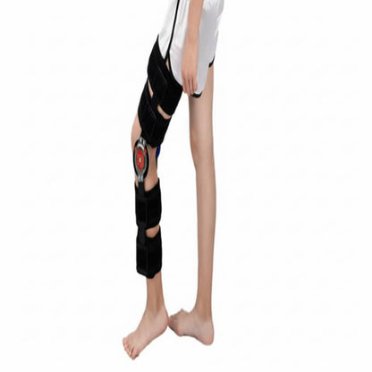 Black knee brace on a person's leg against a white background