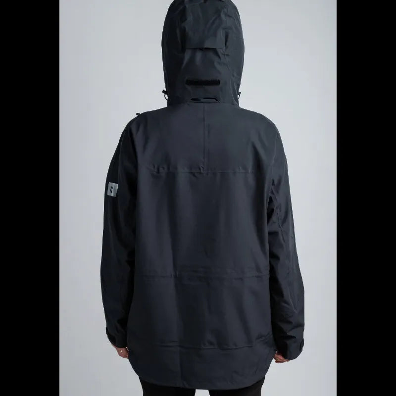 A person shown from the back wearing a dark charcoal black hooded jacket against a light gray studio background.