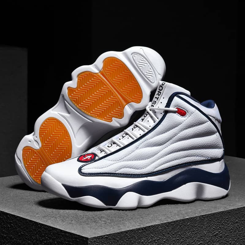 White sneakers with orange soles on a dark background