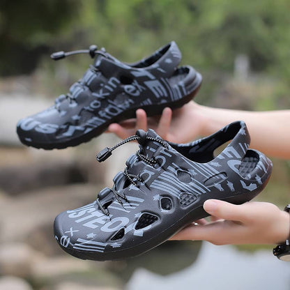 Black and gray shoes held by a person with a natural background
