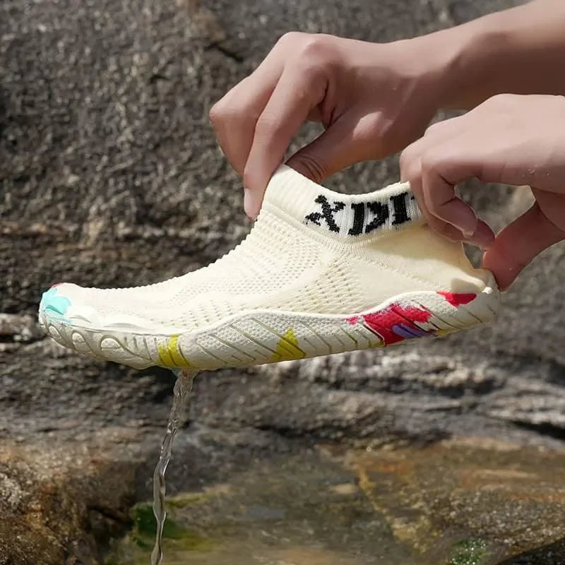 Person holding a white shoe with colorful accents against a natural background