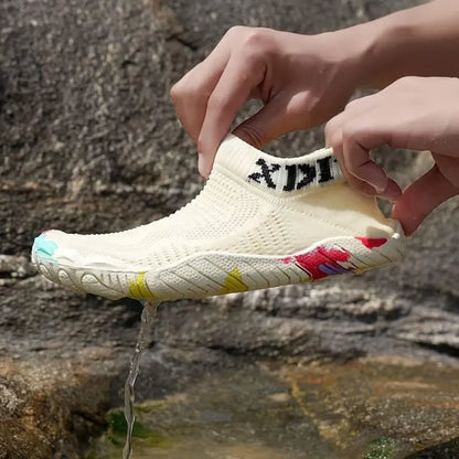 Person holding a white shoe with colorful accents against a natural background