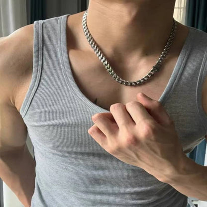 Gray tank top and chain necklace, flexing their arm.