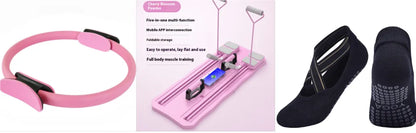 Pink fitness device with digital display, black sandal, and black resistance band on a white background
