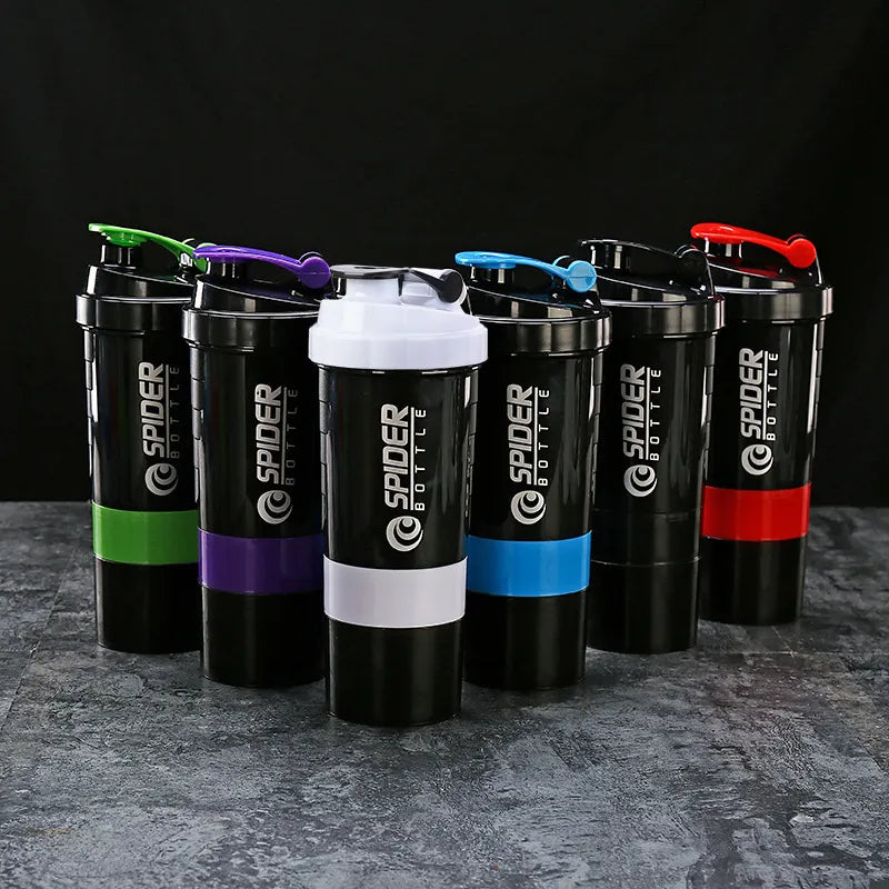 Set of Spider Fitte shaker bottles with colorful handles on a dark surface.