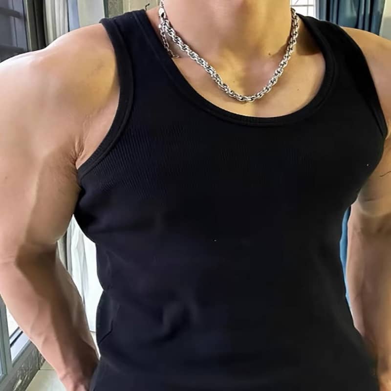 Black tank top and silver chain necklace, flexing muscles.