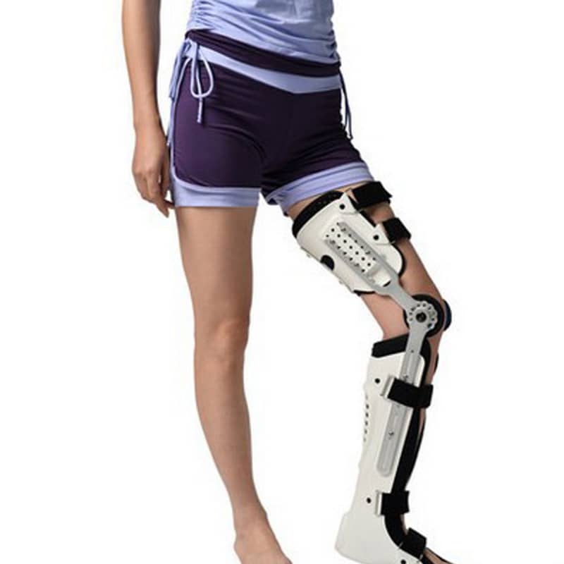 Person wearing a white knee brace on a white background