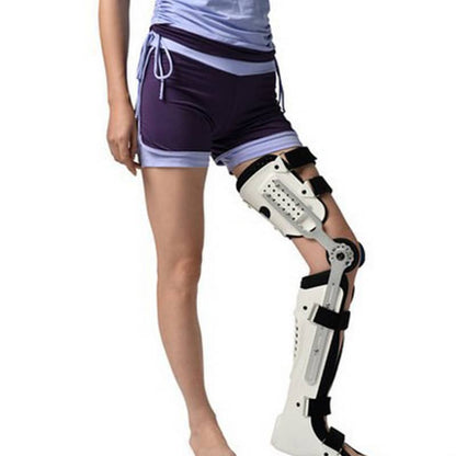 Person wearing a white knee brace on a white background