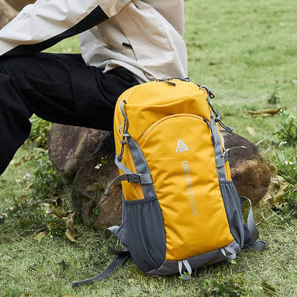 Yellow and gray backpack on grass with person in background
