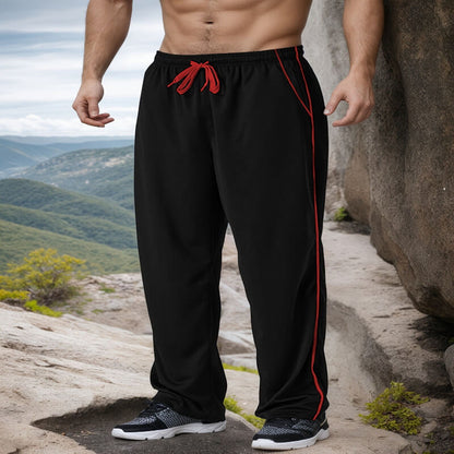 Person wearing black pants with red accents on a mountainous landscape