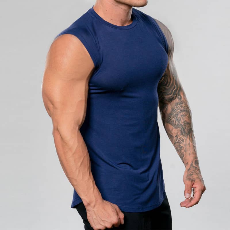 Person wearing a blue sleeveless shirt with a plain background