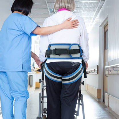 Person using a wheelchair with a safety harness, assisted by a healthcare professional in a hospital setting.