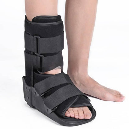 Black foot cast brace on a person's leg against a white background
