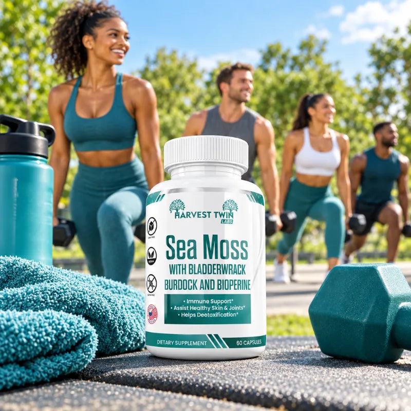 A bottle of Harvest Twin Labs Sea Moss dietary supplement is prominently displayed in the foreground on a workout surface, with a blue towel, water bottle, and dumbbells in the foreground and three people exercising in a sunny outdoor park setting in the background.